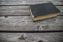 Old worn leather Bible cover on wood table