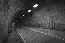 man walking in a highway tunnel 