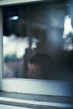 A young boy gazes out the window.