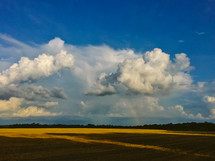 clouds and rainbow over farmland 