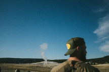 man standing near a geyser 