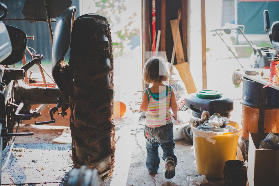 a little girl getting tools in a garage 