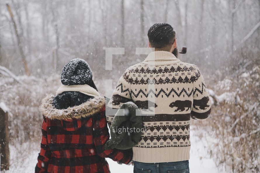 a couple outdoors in falling snow 