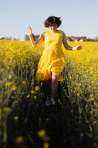 Girl dancing in a yellow field of flowers