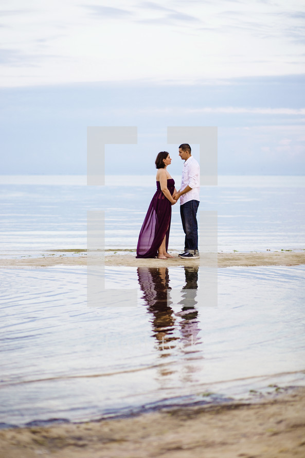 Couple holding hands, standing on a sandbar