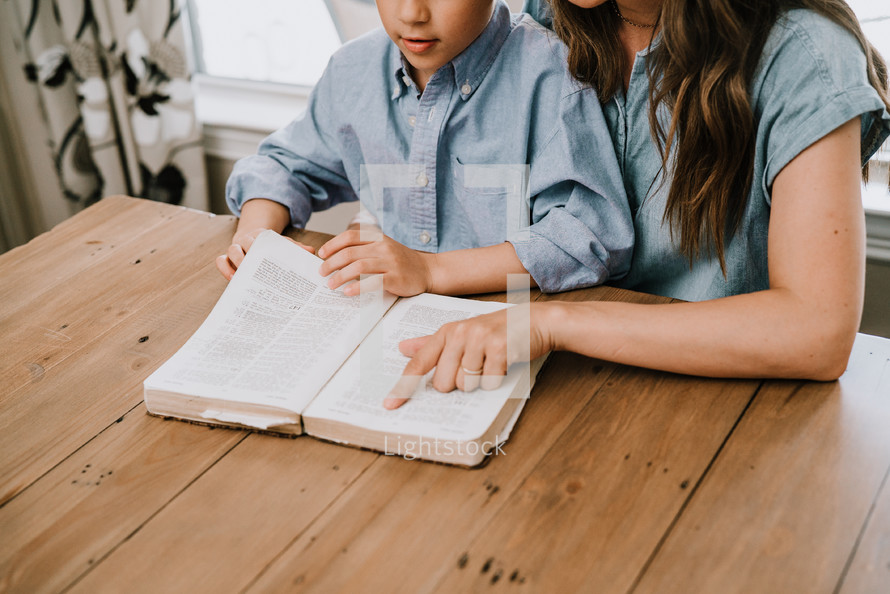 a mother and son reading a Bible together 