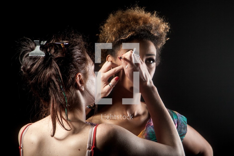 makeup artist fixing a model 