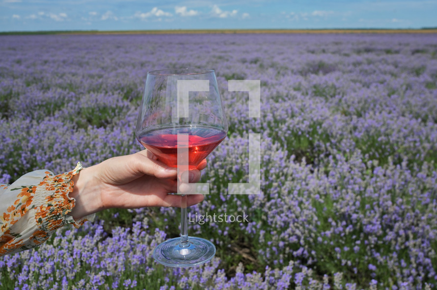 woman in a field of lavender holding a wine glass 