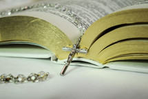 rosary on the pages of a Bible 