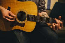 A man playing an acoustic guitar. 