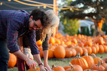 couple picking out pumpkins in a pumpkin patch 