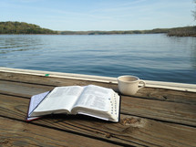 Bible and coffee cup on a dock