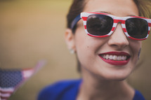 woman wearing stars and stripes sunglasses and a temporary tattoo