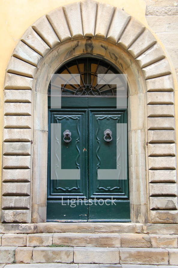 Wooden doors with door knocker in granite frame