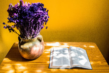 vase of lavender and open Bible on an end table 