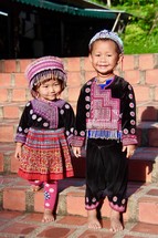 toddlers in traditional clothing holding hands 