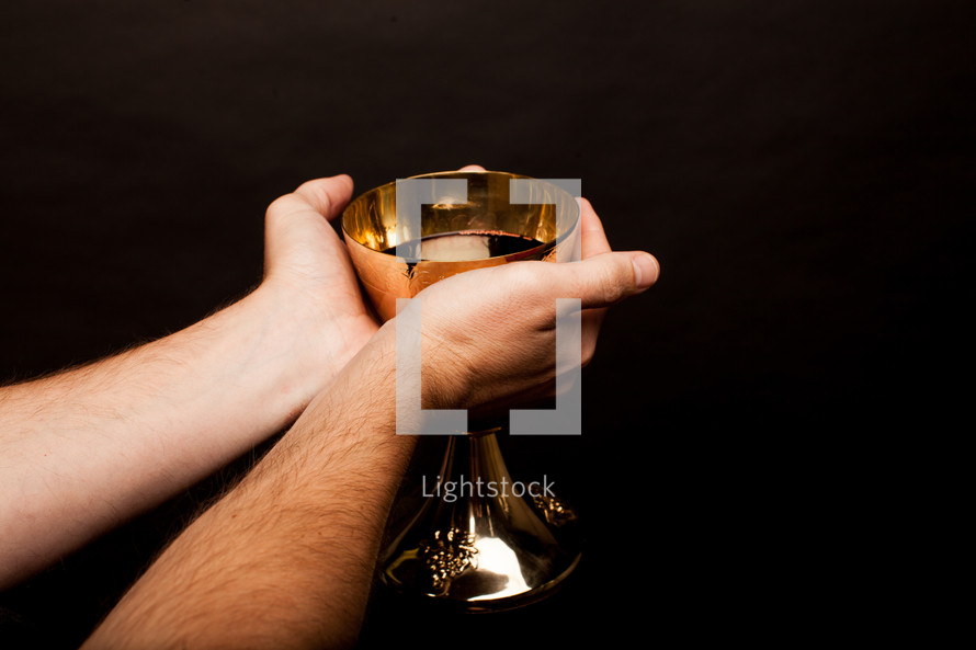 hands holding up a wine chalice 