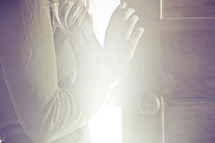 woman standing in the light of an opened door