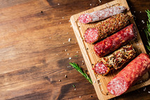 Assortment of various aromatic salami sausages. Against a dark background. High quality photo