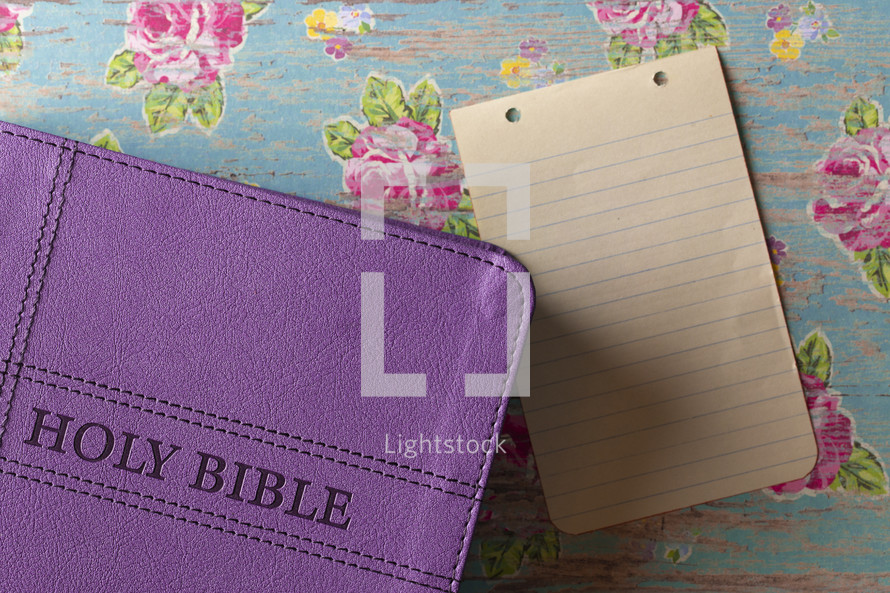 purple Bible and blank paper 