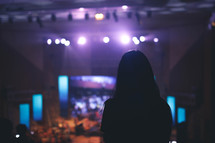 silhouette of a girl watching a concert 