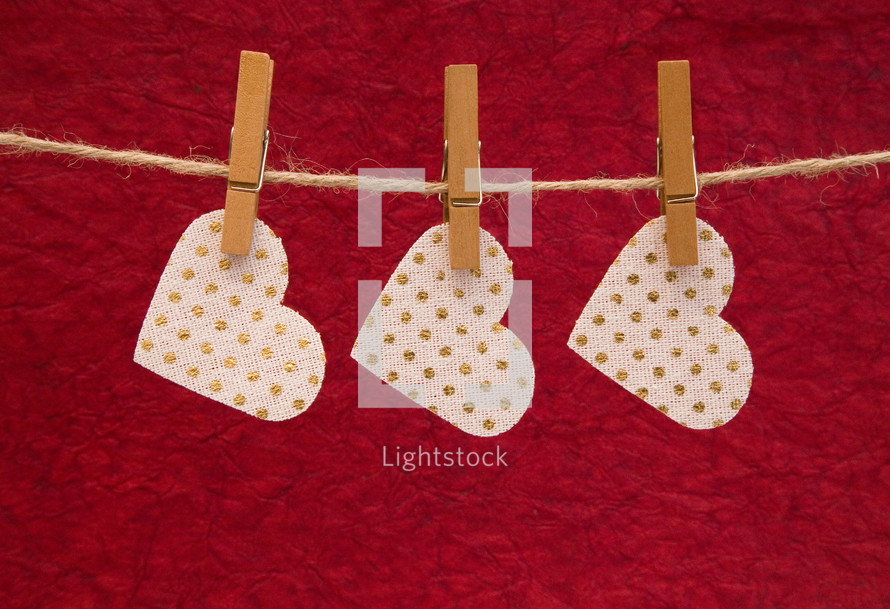 heart shape cutouts hanging by clothespins 