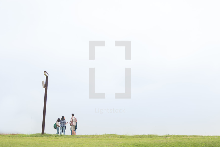 teens at the top of a hill talking 