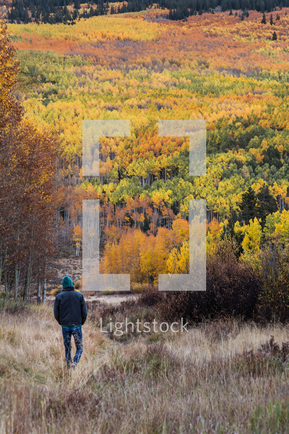 man walking outdoors and fall forest on a mountainside 