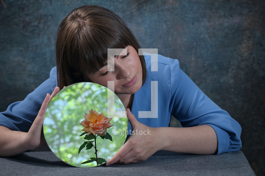 Conceptual Woman Holding A Mirror And Reflection of Rose Flower