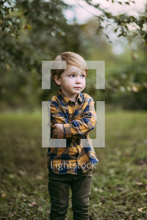 little boy standing outdoors 