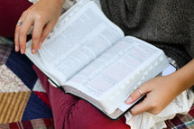 woman reading a Bible sitting on a blanket 