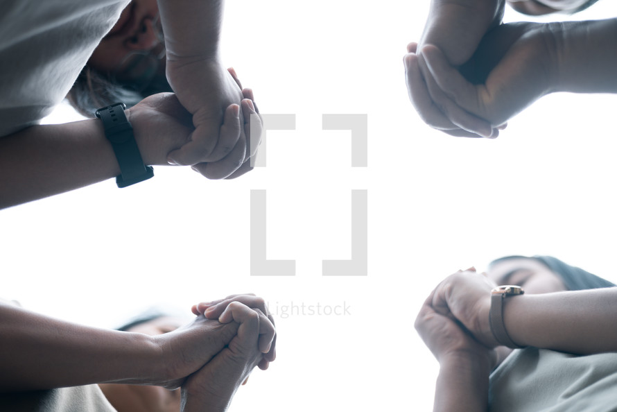 Group praying with hands folded