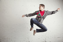 man jumping for joy wearing an ugly sweater. 