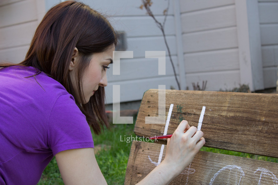 a teen girl painting on a bench 