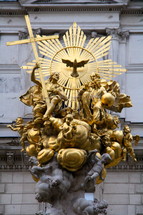 Golden statue depicting the Trinity : The Father, crucified Son and the Holy Spirit surrounded by the angelic host.