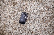 Broken iphone on a granite counter top.