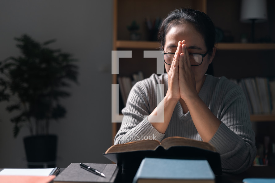 Woman praying on a Bible