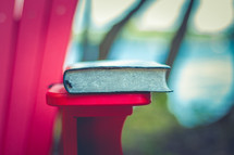 Bible on the edge of a red adirondack chair