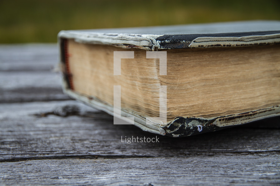 Old worn leather Bible on wood