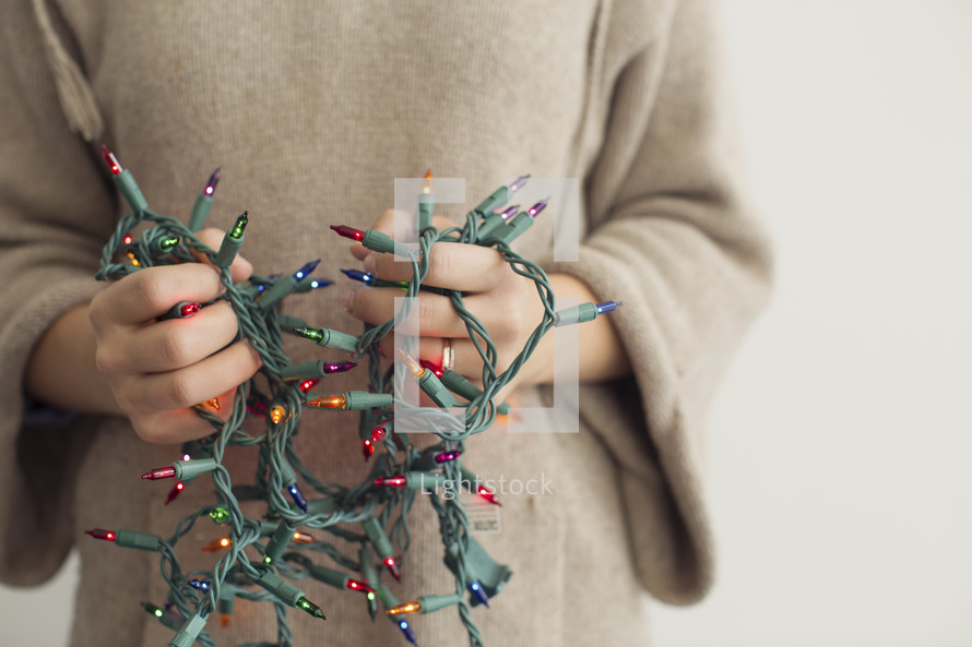 a man holding tangled Christmas lights 