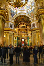 tourists taking pictures of paintings on a dome in a cathedral 