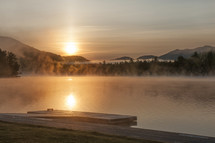 steam and fog over a lake at sunrise 