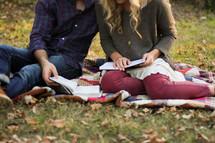 couple sitting on a blanket reading a Bible 