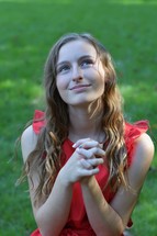 teen girl looking up to God with praying hands 