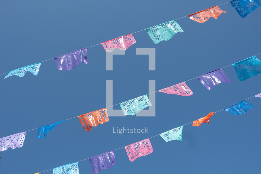 colorful banners hanging against a blue sky 