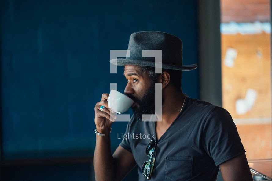 a man sipping from a coffee cup 
