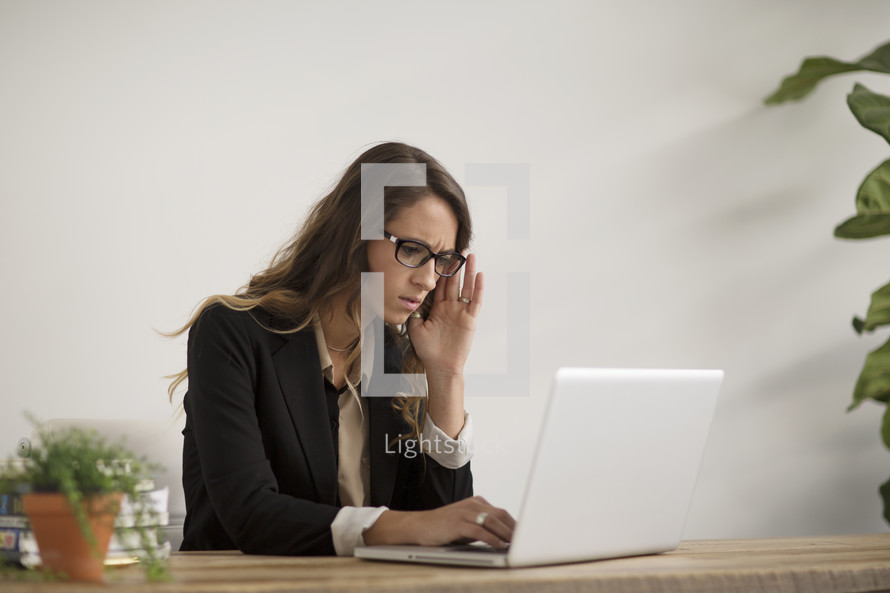a stressed out woman using a laptop computer 