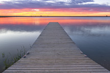 pier over calm water at sunset 