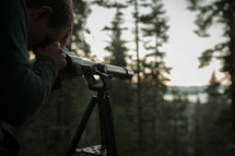 man looking through a scope 