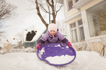 a child sledding in the snow 